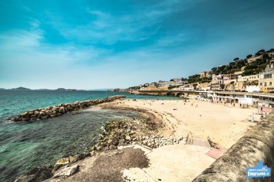 People sunbathe and swim on Prophete Beach on Corniche Kennedy